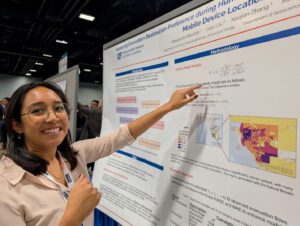 A woman points to a poster on a bulletin board.